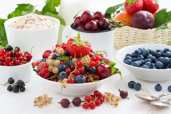 Harvest of fresh berries and fruits on white wooden table — Stock Photo, Image