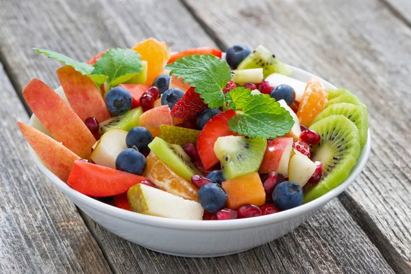 Obst- und Beerensalat auf Holztisch, Nahaufnahme — Stockfoto