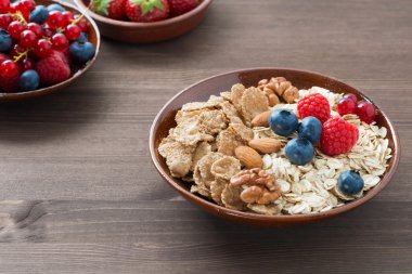 yulaf ezmesi ve bir kase müsli, ahşap arka plan üzerinde taze çilek