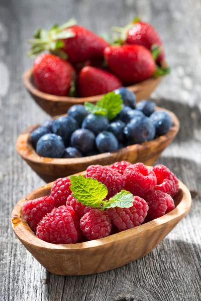Assortment of fresh seasonal berries in a wooden bowl, closeup — Stock Photo, Image