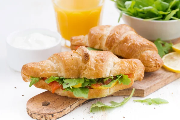 Fresh croissant stuffed with fish and arugula for breakfast — Stock Photo, Image