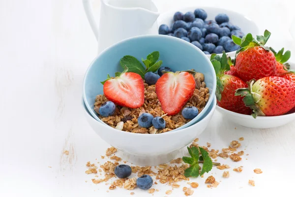 Gezonde voeding - muesli, verse bessen en kruik van melk op tafel — Stockfoto