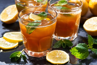 Nane ve limon koyu arka plan üzerinde bardaklarda buzlu çay