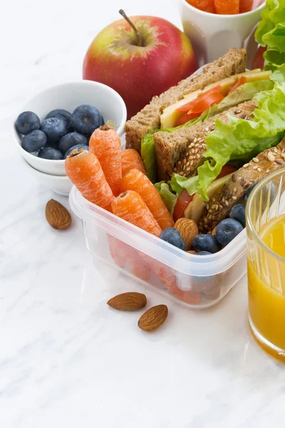 Lunchbox mit Sandwich aus Vollkornbrot auf weißem Tisch — Stockfoto