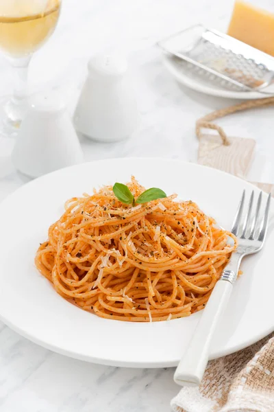 Pasta con salsa di pomodoro su un piatto bianco, verticale, primo piano — Foto Stock