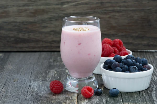 Milkshake and fresh berries on wooden background — Stock Photo, Image