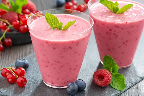Milkshake with fresh berries and mint in glass — Stock Photo, Image