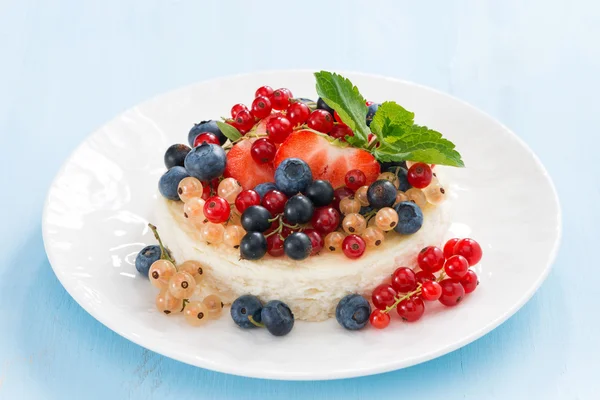 Mini cheesecake with fresh berries on a blue background — Stock Photo, Image