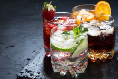 assortment of iced fruit drinks on a dark background clipart