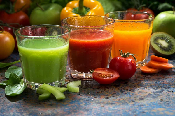 Assortiment de jus de légumes sur fond bleu, gros plan — Photo