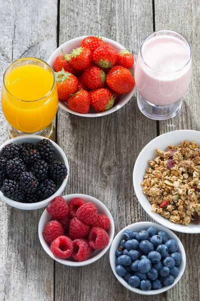Zdravá snídaně s plody na dřevěné pozadí, vertikální — Stock fotografie