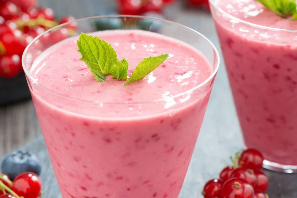 Milkshake with fresh berries and mint in glass, close-up — Stock Photo, Image