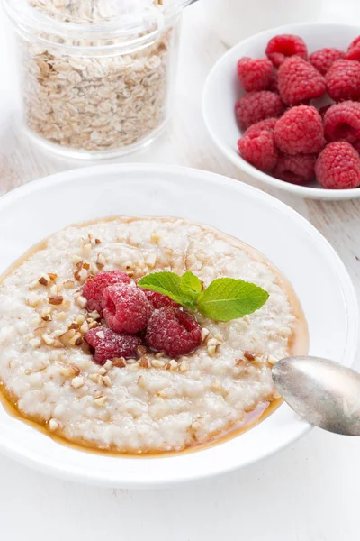 Oatmeal with raspberries and honey, vertical, close-up — Stock Photo, Image