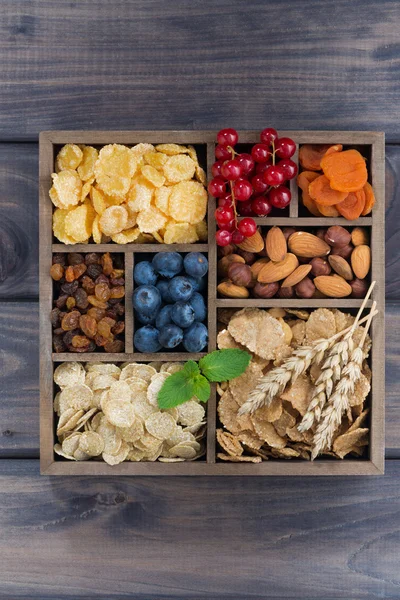Завтрак хлопья, сухофрукты, ягоды и орехи в деревянной коробке — стоковое фото