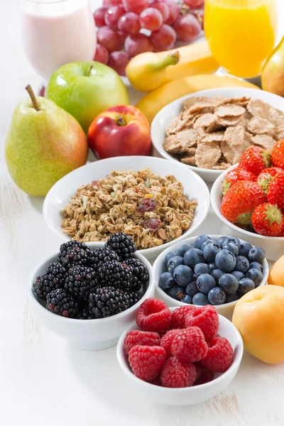 Bagas frescas, frutas e muesli para o café da manhã na mesa branca — Fotografia de Stock