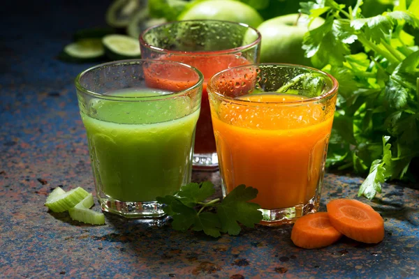 Vasos de jugo fresco de apio y zanahorias en la mesa oscura — Foto de Stock