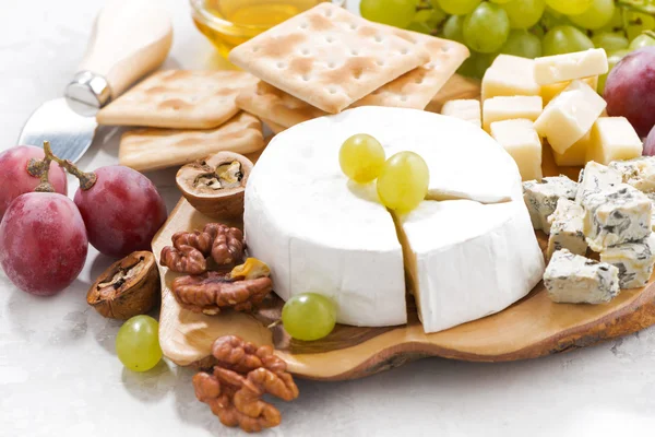 Camembert, üzüm ve beyaz bir tabloda, closeup kraker — Stok fotoğraf