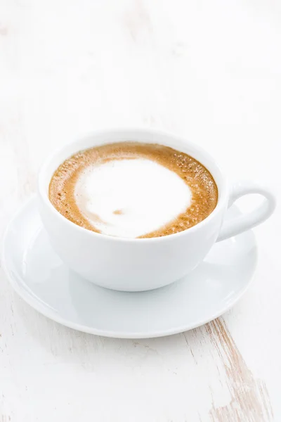 Taza de capuchino sobre una mesa de madera blanca, vertical — Foto de Stock