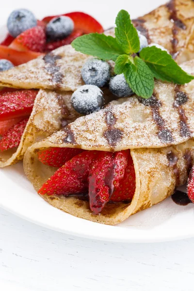 Crepes with fresh berries and chocolate sauce, vertical, closeup — Stock Photo, Image