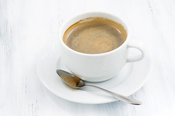 Taza de café negro sobre mesa de madera blanca — Foto de Stock