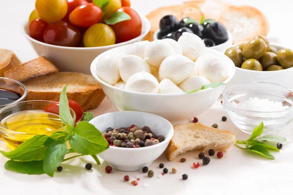 Ingredientes frescos para ensalada con mozzarella sobre mesa blanca —  Fotos de Stock