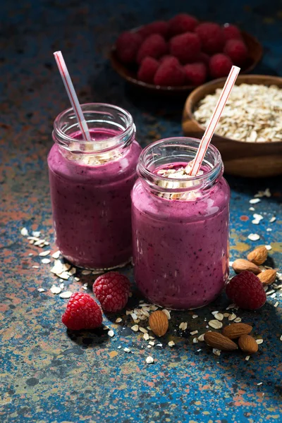 Healthy berry smoothies with oatmeal in bottles — Stock Photo, Image