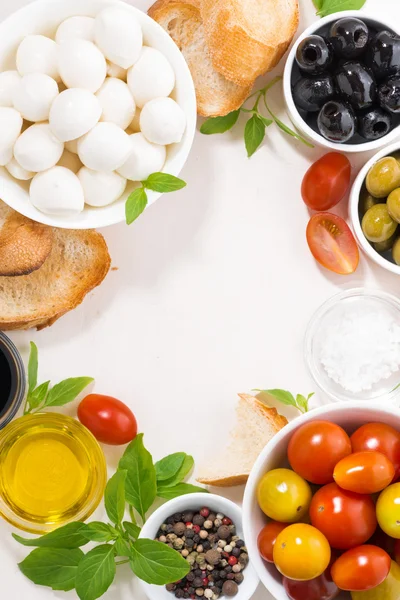 Ingredienser för sallad med mozzarella på vitt bord, vertikal — Stockfoto