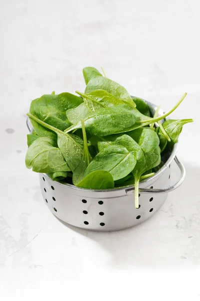 Fresh clean spinach in a metal colander, vertical — Stock Photo, Image