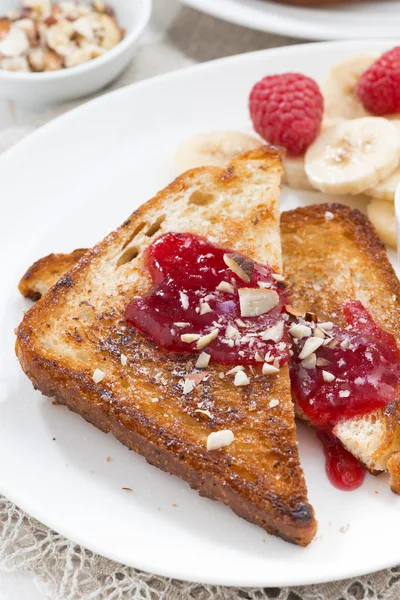 Sweet breakfast - toasts with raspberries, banana and jam — Stock Photo, Image