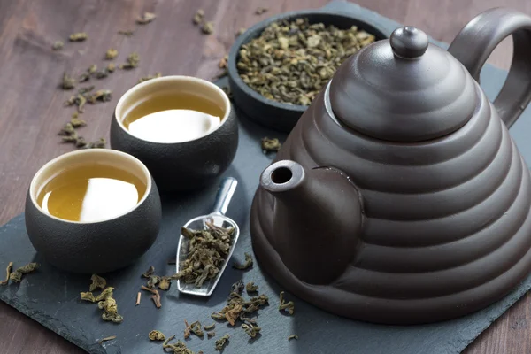 Teapot and cups with green tea, selective focus — Stock Photo, Image