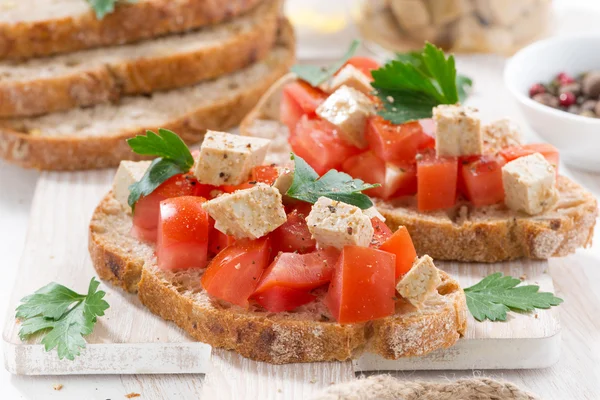 Torradas com tomates e feta marinada, close-up — Fotografia de Stock