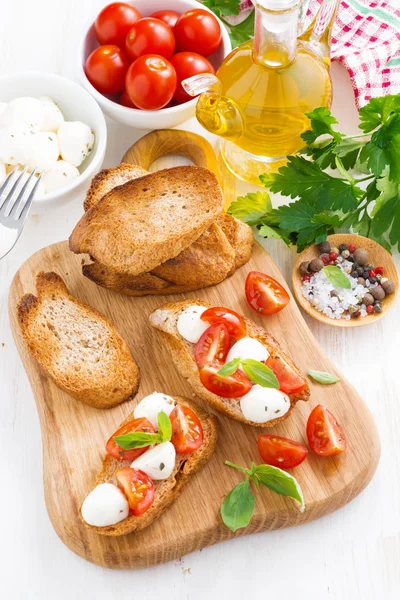 Rostat bröd med mozzarella, basilika och körsbärstomater — Stockfoto