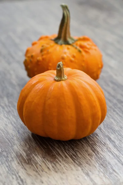 Decorative pumpkins on wooden background, vertical — Stock Photo, Image