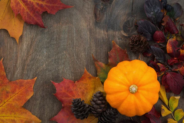 Wooden background with seasonal pumpkin and leaves, top view — Stock Photo, Image