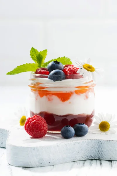 Dessert with jam, cream and fresh fruit in a glass jar, closeup — Stock Photo, Image