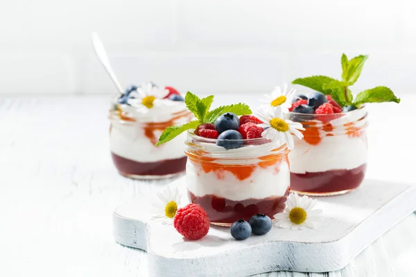 Десерт з джемом, вершками та свіжими фруктами у скляних банках — стокове фото