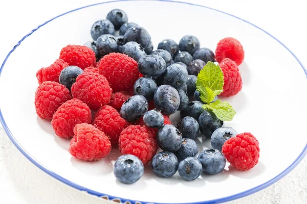 Teller mit frischen Beeren auf weißem Hintergrund — Stockfoto