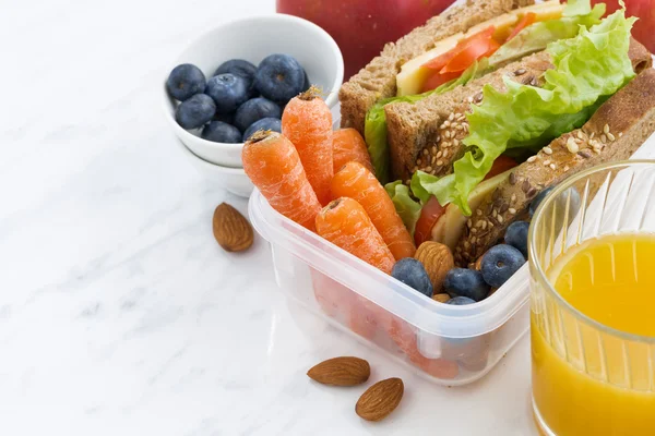 Lunch box with sandwich of wholemeal bread on white table — Stock Photo, Image