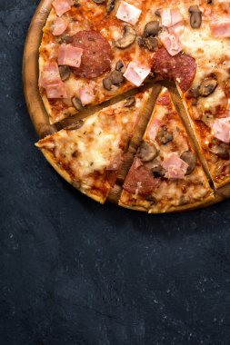 Peynir ve sosis siyah bir arka plan, üstten görünüm pizza