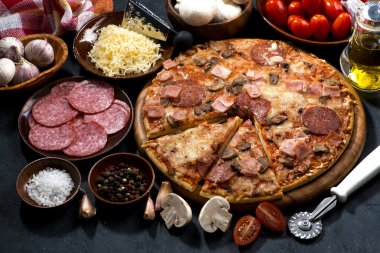 Salam ve karanlık bir arka plan, üstten görünüm malzemelerle pizza