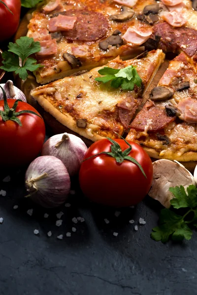 Pizza med korv och ost och ingredienser på mörk bakgrund — Stockfoto