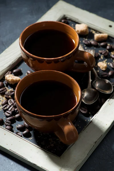 Cups of black coffee and sugar on the blackboard, vertical — Stock Photo, Image