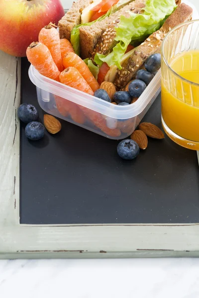 Lunchbox mit Sandwich aus Vollkornbrot auf Tafel — Stockfoto