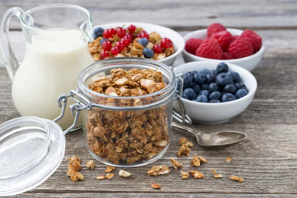 Jar with granola, milk, and fresh berries — Stock Photo, Image