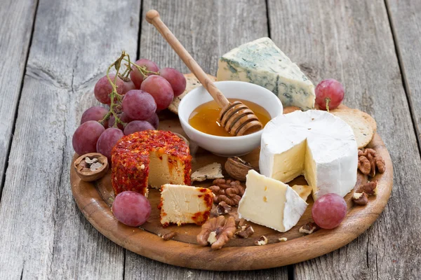 Weichkäse und Snacks auf einem hölzernen Hintergrund — Stockfoto