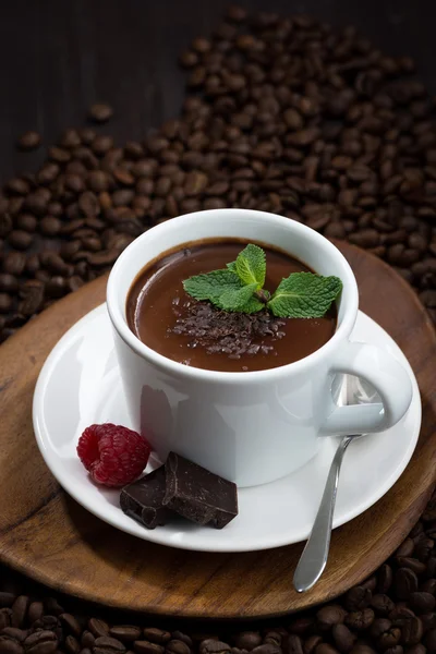 Aromatisierte heiße Schokolade auf einem Hintergrund aus Kaffeebohnen, vertikal — Stockfoto