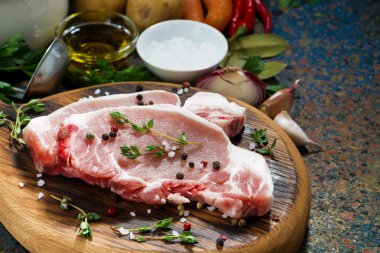 iki adet ahşap kesme tahtası ve malzemeler üzerinde çiğ domuz eti