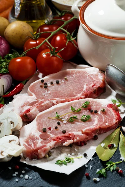 Two pieces of raw pork and fresh ingredients for soup, closeup — Stock Photo, Image