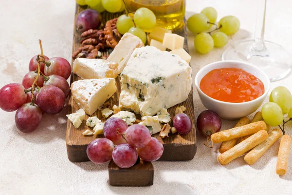 Сырная доска, свежий виноград и мед на белом фоне — стоковое фото