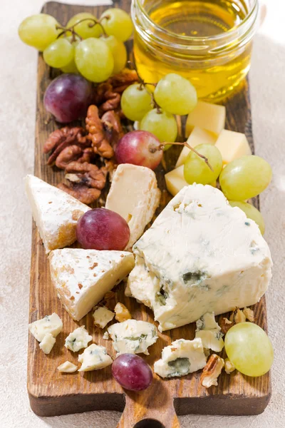 Planche à fromage, fruits frais et miel sur fond blanc — Photo